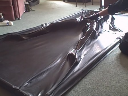 Fi In The Latex Vac Bed - Fi has slipped, completely naked, into a black, latex vac bed.  It is her first experience and she is trembling slightly.

the bed has been zipped shut  and the power switched on.  The pump slowly withdraws the air from the bed, allowing fi to feel the latex compress on to her skin.

what she doesn't expect is the latex hand that drips polish all over the latex covering her naked body and then starts to shine her up.  Watch the clip to see her response!